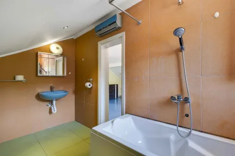 Kupatilo sa kadom, umivaonikom i pločicama braon boje. - image 44