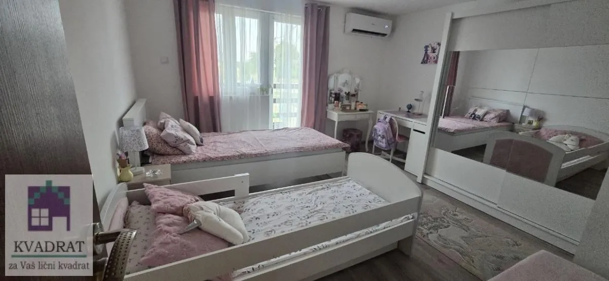 Dečja spavaća soba sa dva kreveta i velikim garderoberom.