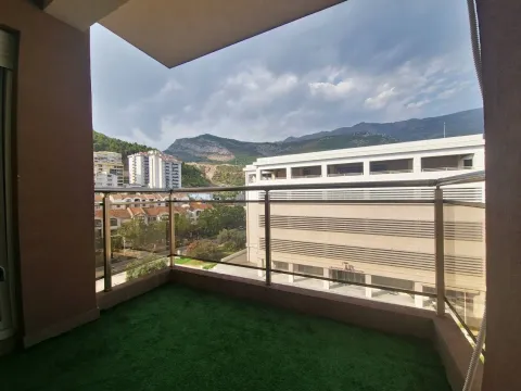 Covered balcony with artificial grass flooring and a view of the city and mountains. - image 8