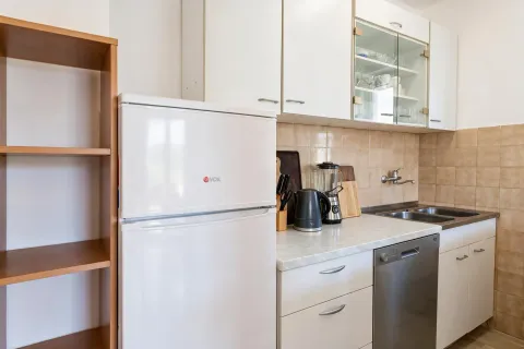 Small bright kitchen with white cabinets, refrigerator, and sink. - image 6