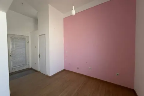 Empty room with wooden flooring and one pink wall. - image 4