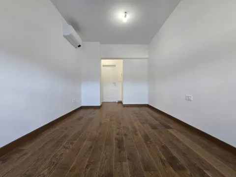 Empty room with wooden flooring and an air conditioner. - image 18