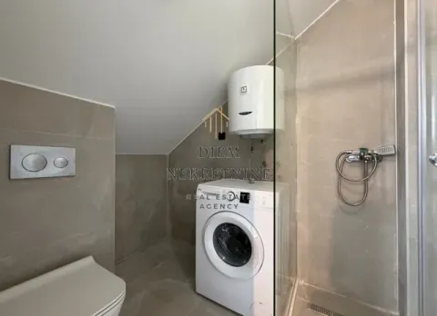 Modernly equipped bathroom with a shower cabin, water heater, and washing machine. - image 3