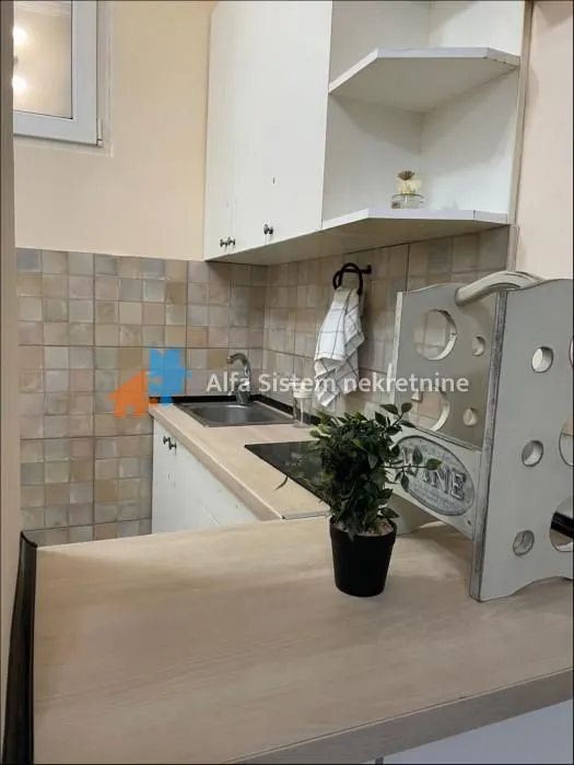 Small kitchen with white cabinetry and a sink.