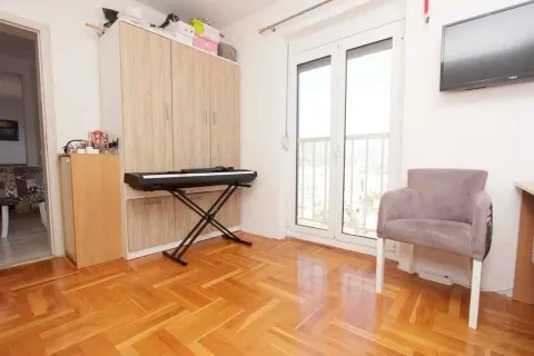 Svijetla soba sa parketom, ormarom, električnom klavijaturom i izlazom na balkon. - image 11