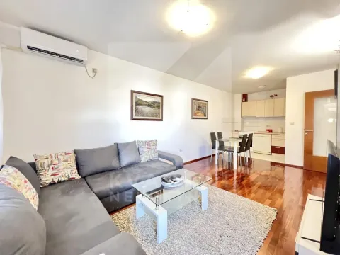 Living room with sofa, dining area, and kitchen in the background. - image 3