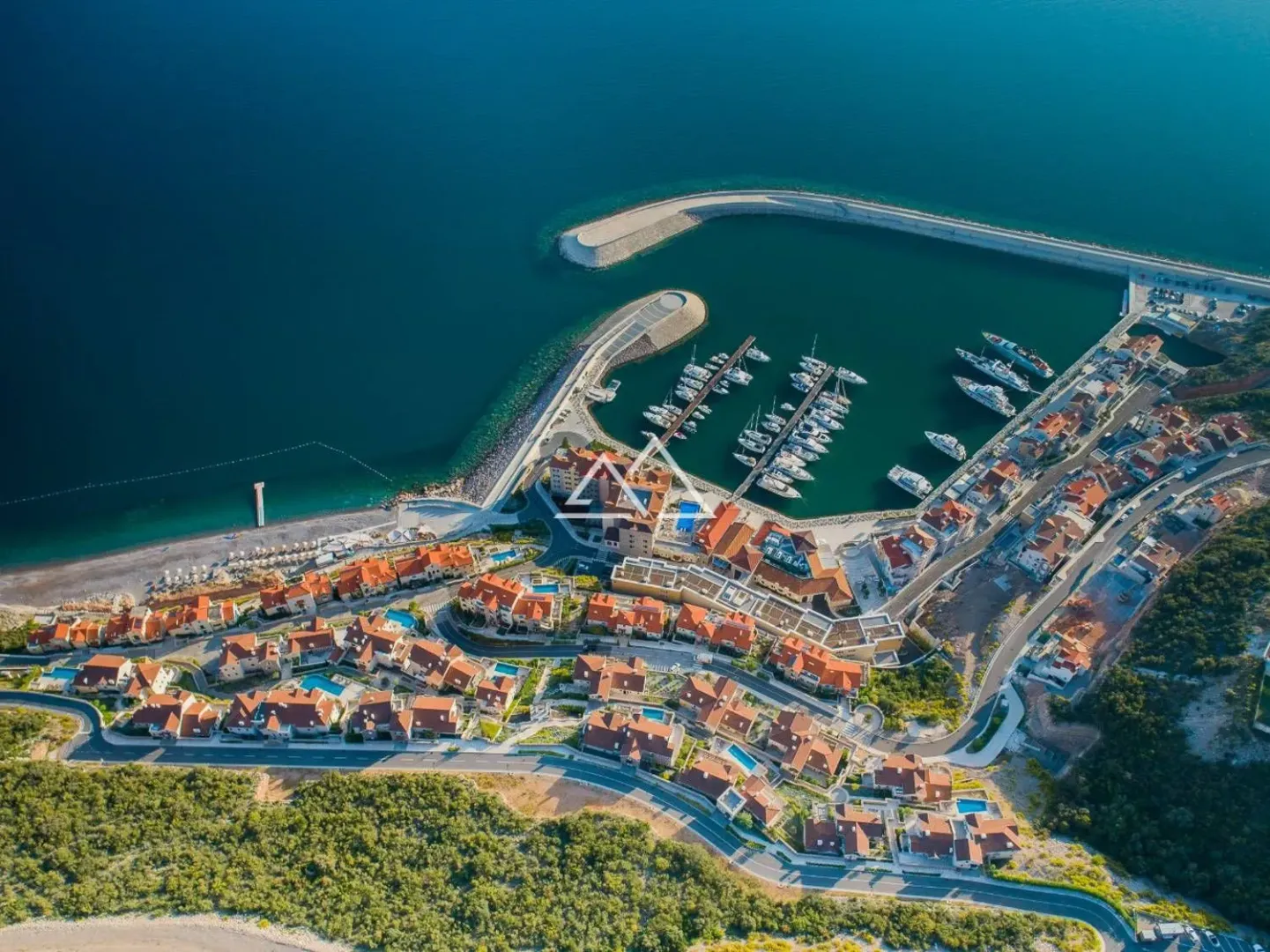 Pogled iz vazduha na obalu sa marinom i naseljem.