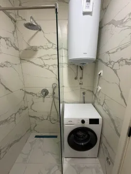 Savremeno opremljeno kupatilo sa tuš kabinom i veš mašinom. - image 6