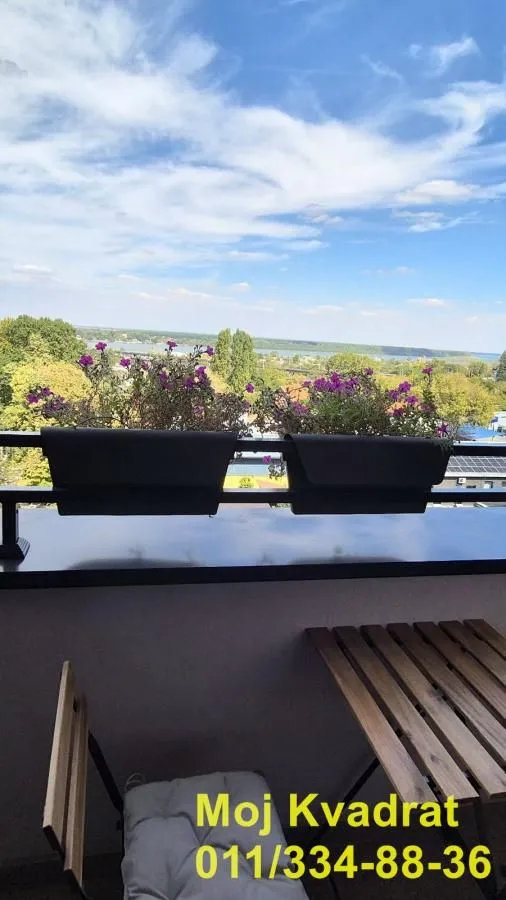 Furnished balcony with a wooden table, chairs, and a nice view of nature.