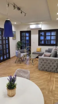 Dnevna soba sa garniturom, foteljom, stočićem i parketom na podu. - image 2