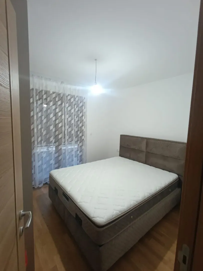 Pogled na urednu spavaću sobu sa bračnim krevetom.