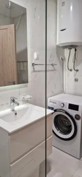 Svijetlo i moderno kupatilo sa veš mašinom i lavaboom. - image 12
