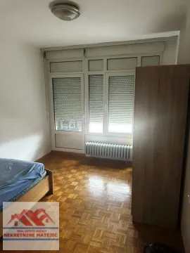 Nameštena spavaća soba sa krevetom, drvenim ormanom i parketom. - image 4