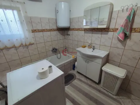 Bathroom equipped with a bathtub, sink, and water heater. - image 27
