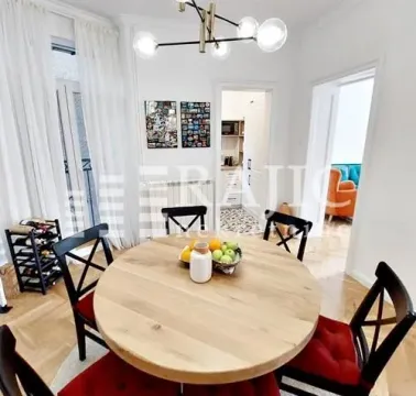 Trpezarija sa okruglim drvenim stolom i crnim stolicama. - image 3