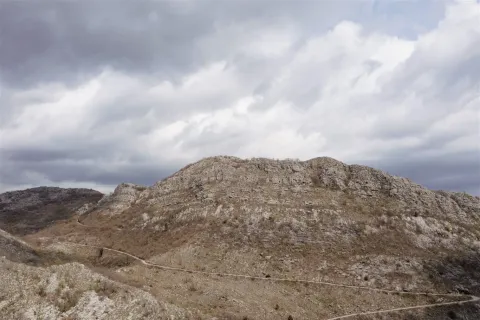 Širok pogled na planinski predio i brdoviti teren pod oblačnim nebom. - image 7