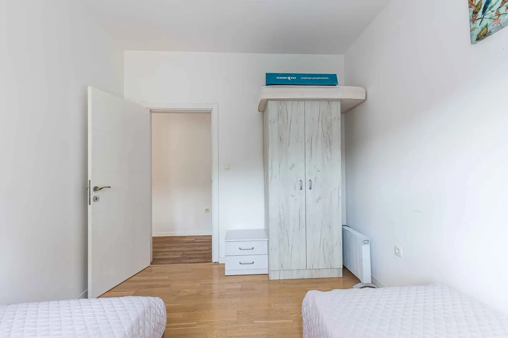 Smaller bedroom with two single beds and a wardrobe.