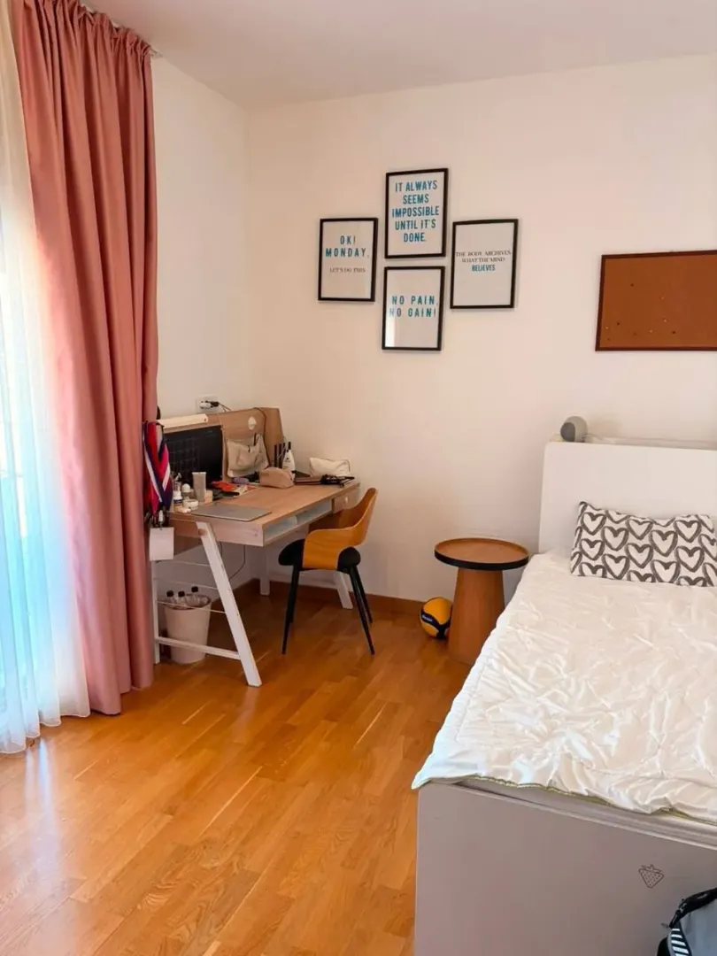 Dječija soba sa krevetom, radnim stolom i drvenim podom.