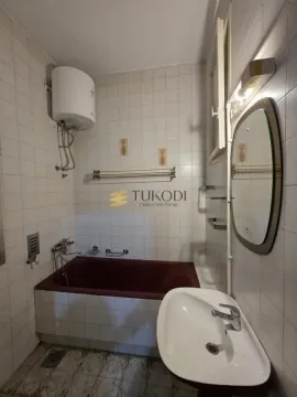 Bathroom with a bathtub, washbasin, mirror and water heater. - image 9