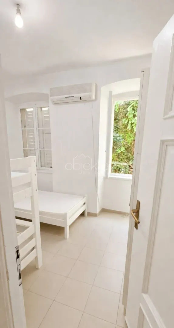 A view of a bedroom with a bunk bed through an open door.