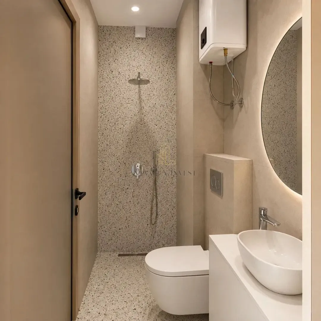 Modern bathroom with a shower enclosure, washbasin and toilet.