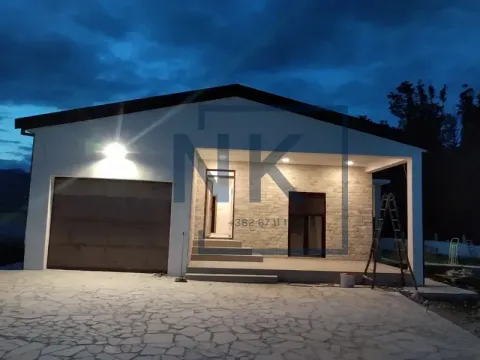 Exterior view of the house with lighting at night and a garage door. - image 3