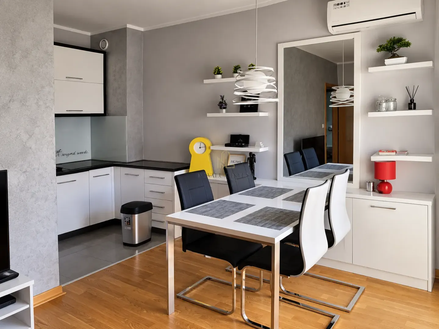 Small kitchen with a dining table and white cabinets.