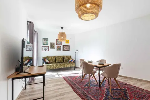 Living room with a sofa set, television, and dining table. - image 5