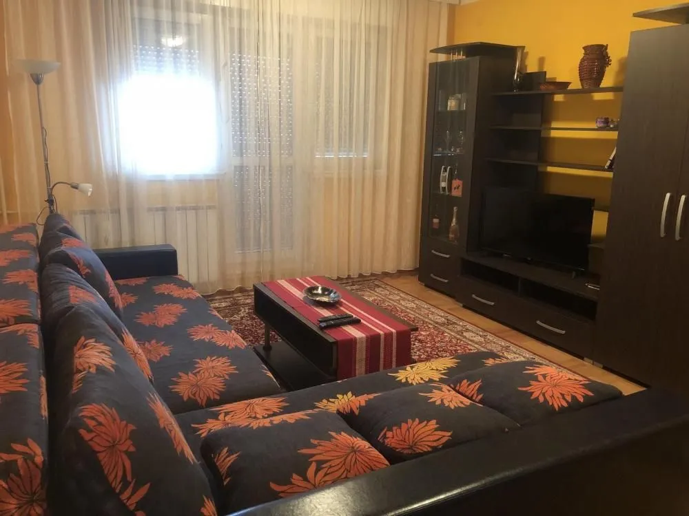 Living room with a corner sofa, TV and chest of drawers.