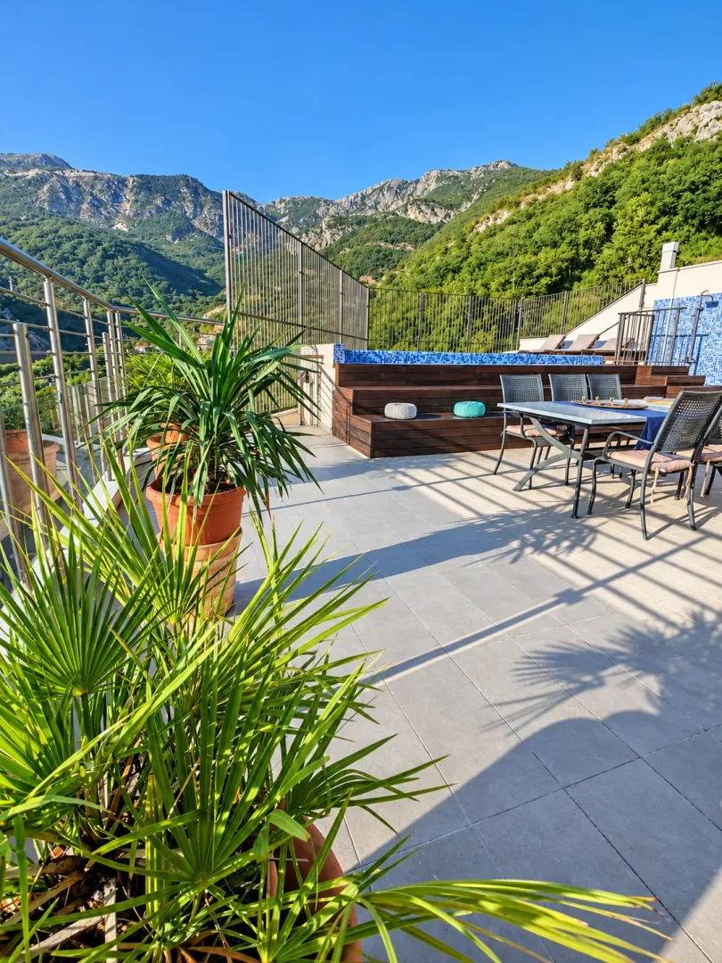Spacious terrace with seating, a pool, and mountain views.