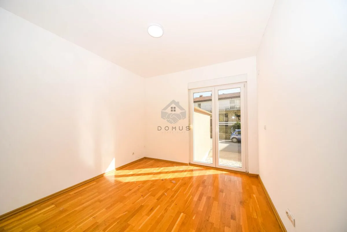 Empty room with wooden flooring and access to the terrace.