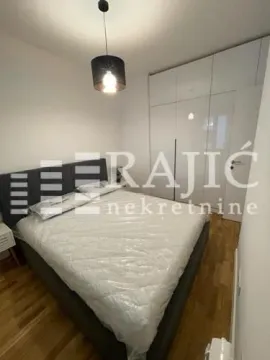 Modern bedroom with a double bed and built-in wardrobe. - image 4
