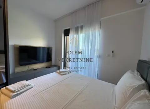 Furnished bedroom with a double bed and a television. - image 10
