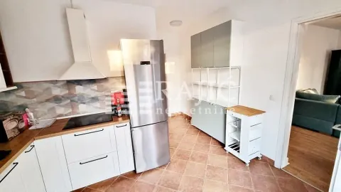 Moderna kuhinja sa belim elementima, frižiderom i pločicama na zidu. - image 12
