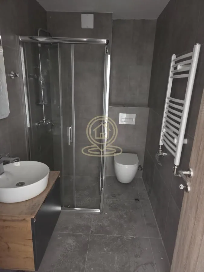 Savremeno opremljeno kupatilo sa tuš kabinom, umivaonikom i WC šoljom.