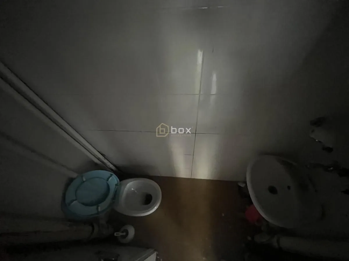 Top-down view of a small equipped bathroom with a toilet and washbasin.