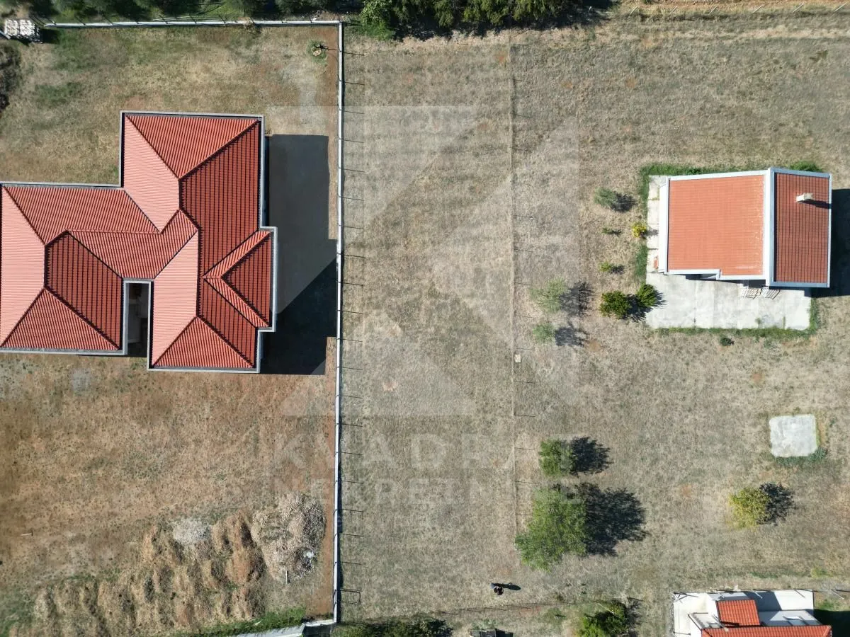 Pogled iz vazduha na kuće sa dvorištem i okolnim zemljištem.
