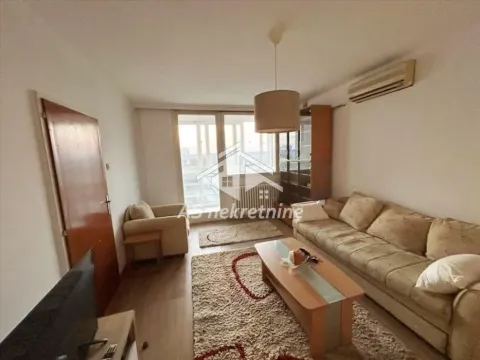 Living room with a sofa, coffee table and balcony access. - image 12