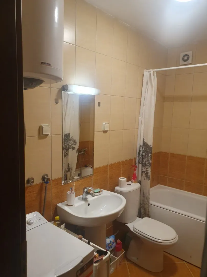 A bathroom with a bathtub, sink, and washing machine.