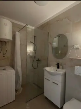 Savremeno opremljeno kupatilo sa tuš kabinom, umivaonikom i veš mašinom. - image 13