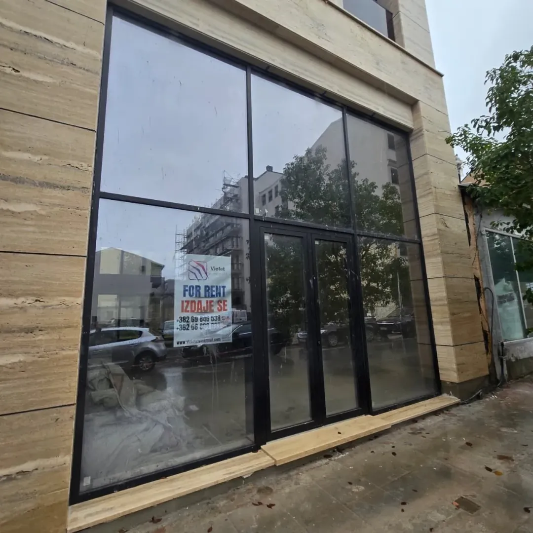 Commercial space facade with a large glass storefront and a for rent sign.