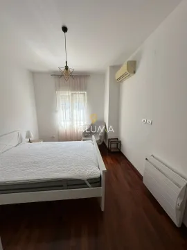 Spavaća soba sa bračnim krevetom, foteljom i drvenim podom. - image 5