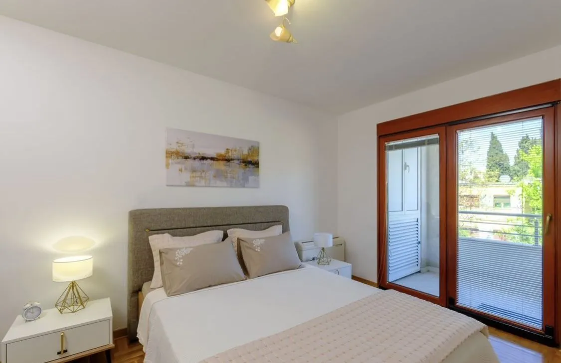 Bright bedroom with a double bed and terrace access.