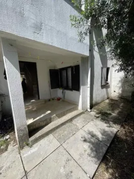 View of the house entrance with a yard and paved area. - image 6