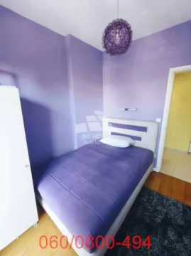 Spavaća soba sa krevetom i ljubičastim zidovima. - image 5