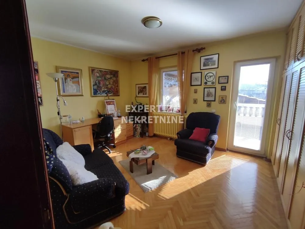 Living room with a sofa set, desk, and parquet flooring.