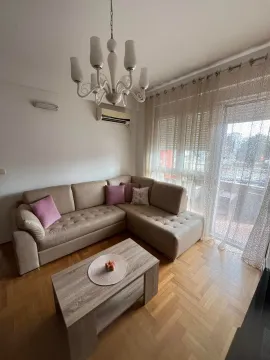 Living room with a corner sofa, coffee table, and balcony access. - image 2