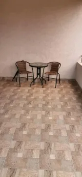 A terrace with a tiled floor, a small table, and two chairs. - image 12