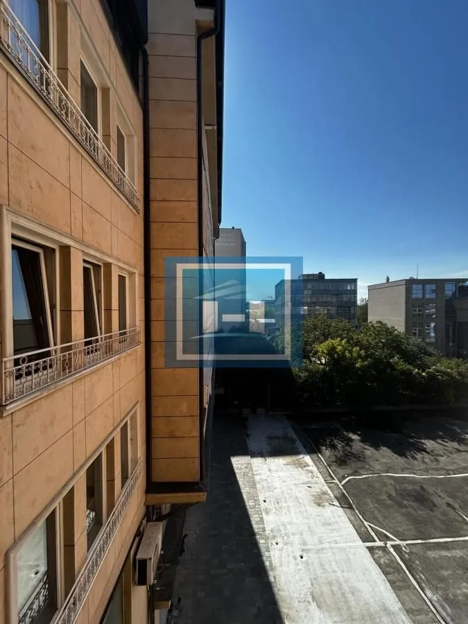 Pogled sa terase zgrade na okolne objekte i parking.