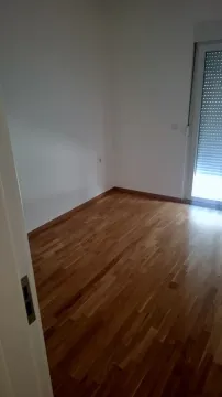Prazna soba sa drvenim podom i balkonskim vratima. - image 3